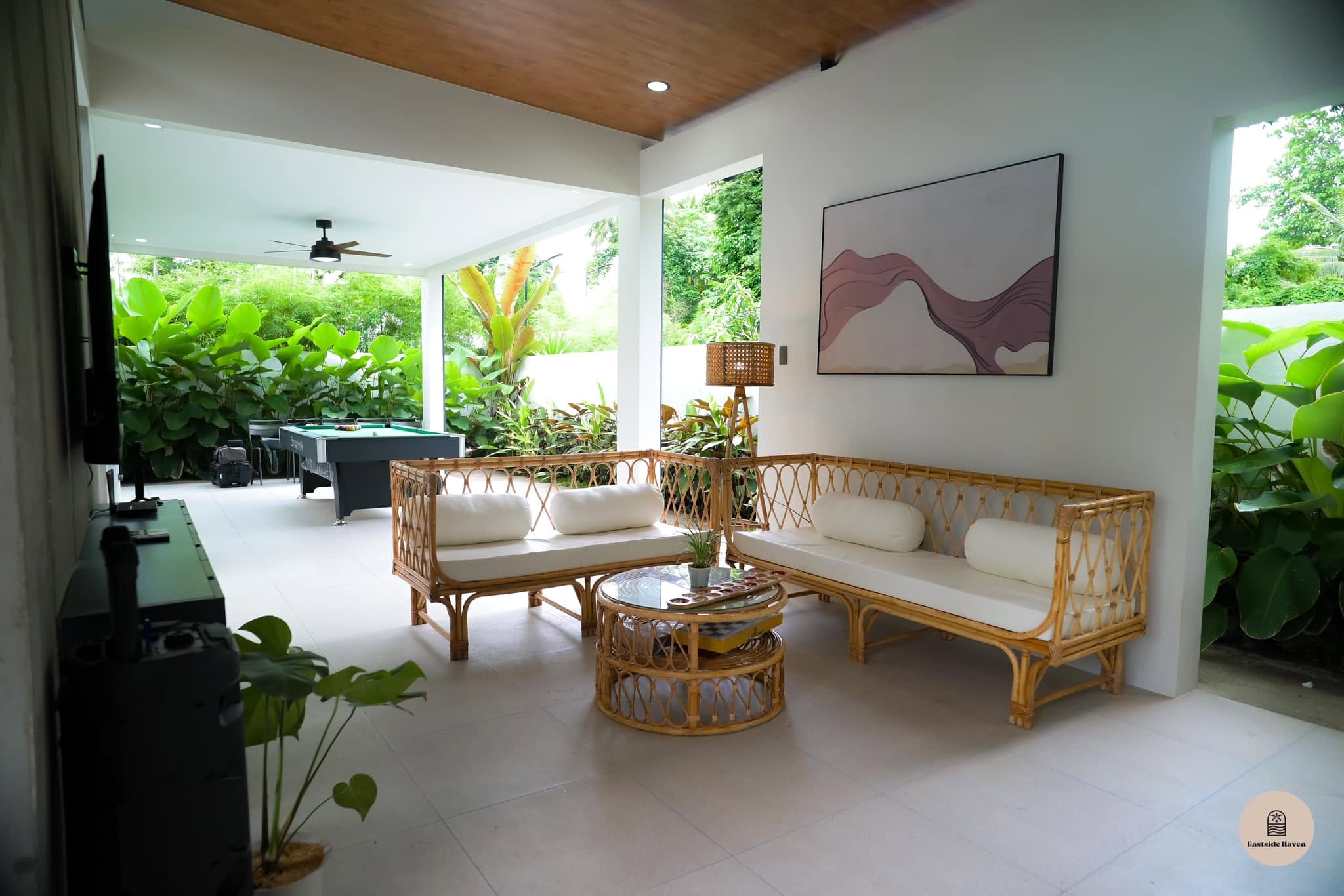 Covered lounge with rattan sofas, billiards table and TV