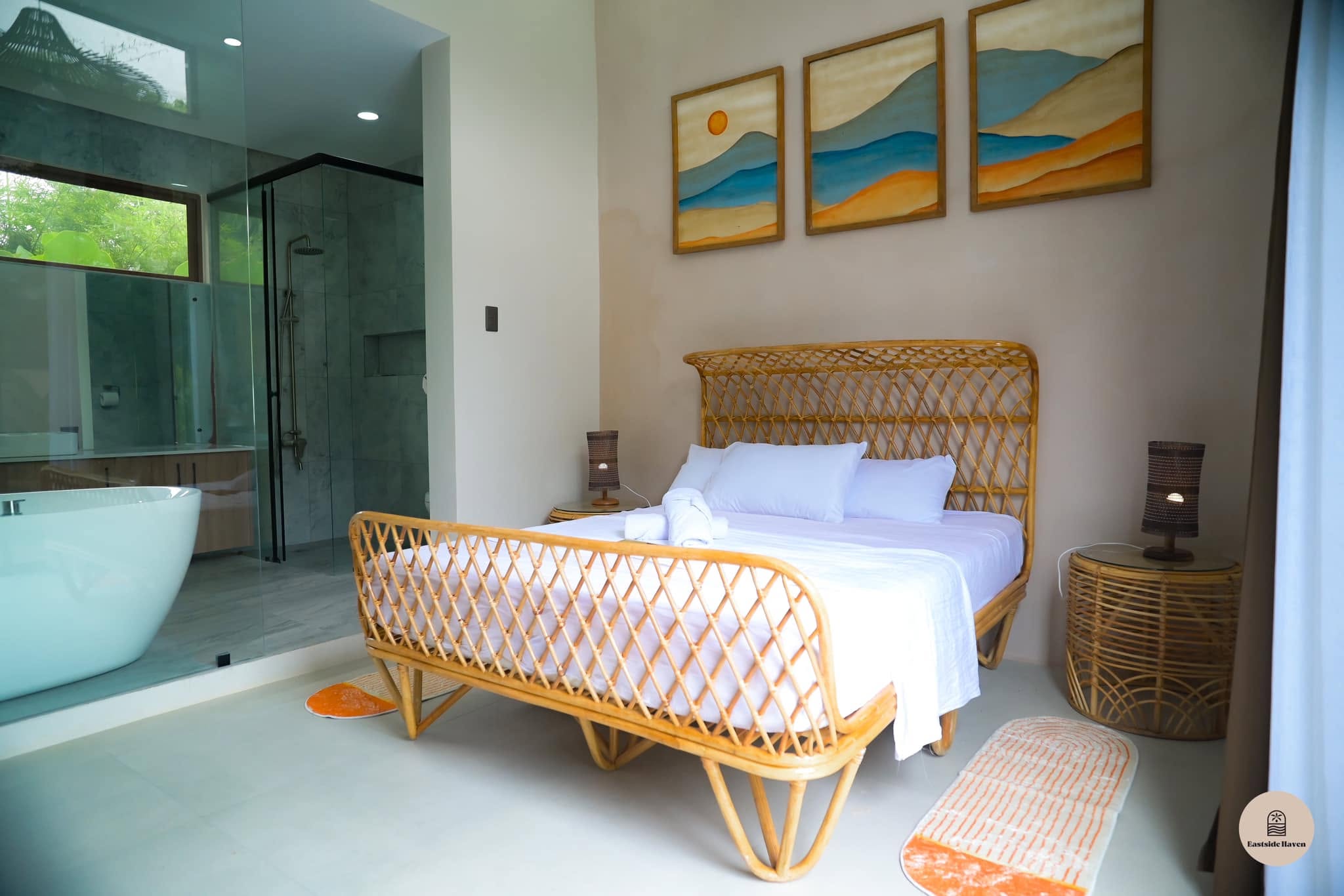 Master bedroom with rattan bed and freestanding tub